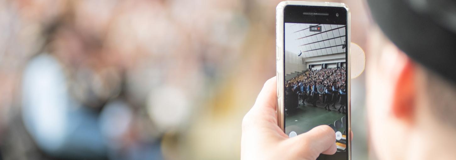 A student records a video on their smartphone.